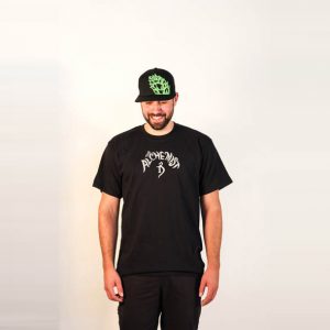 Male modeling Black tee with silver Alchemist logo. Front view